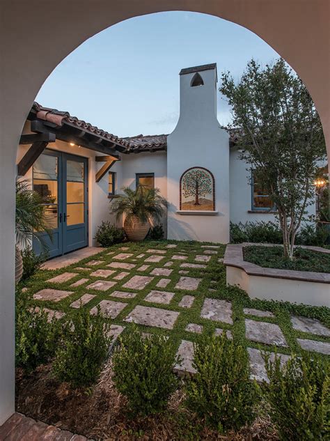 The courtyard pavers are different shapes and sizes, the tile roof is outlined, archways on the old Spanish-style building appear distressed, and the tree in the foreground is nicely portrayed. . Spanish courtyard